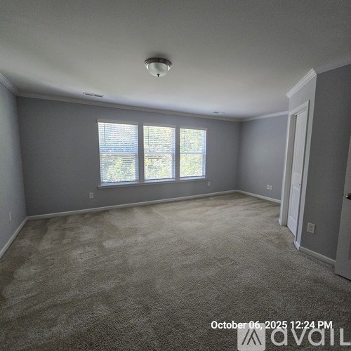 A room with a carpeted floor and a window with blinds.