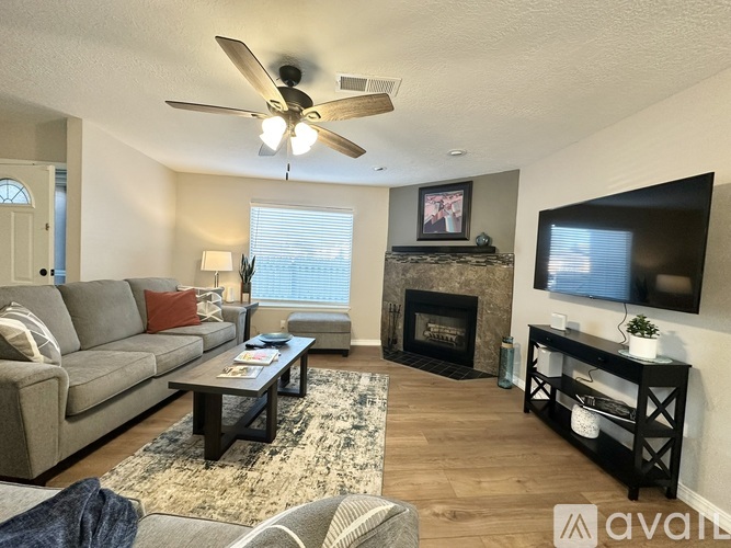 A room with a fireplace and a ceiling fan.