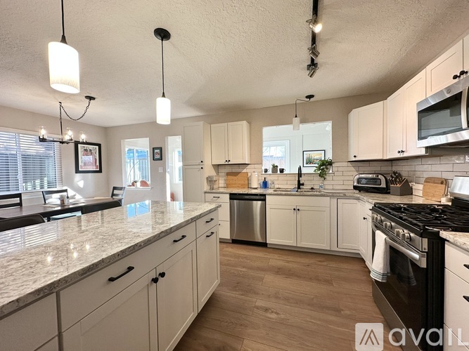 A kitchen with white cabinets and stainless steel appliances.