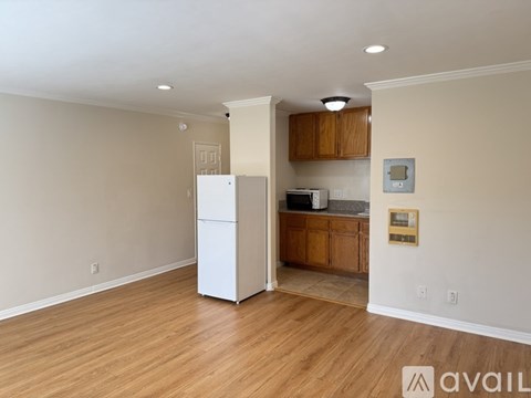 A kitchen area with a white refrigerator and wooden cabinets.