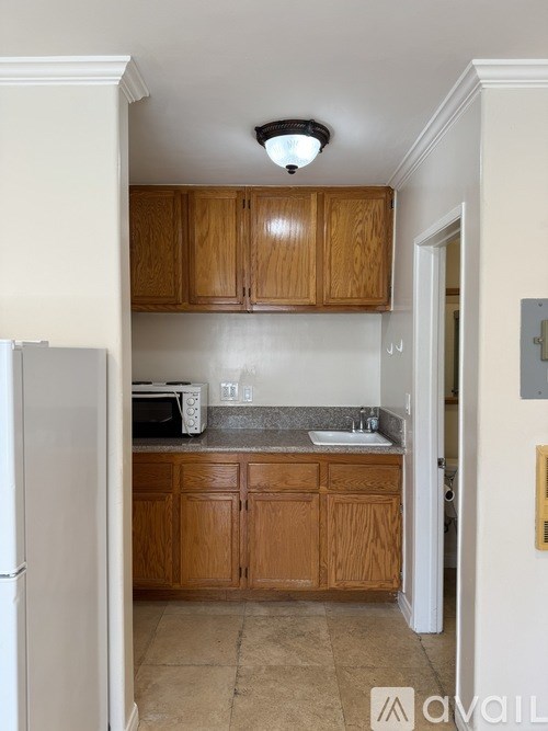 A kitchen with wooden cabinets and a white refrigerator.