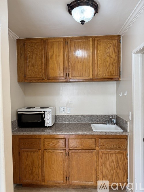 A kitchen with wooden cabinets and a white toaster oven on the counter.