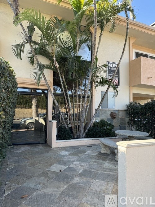 A house with a driveway and a tree in front.