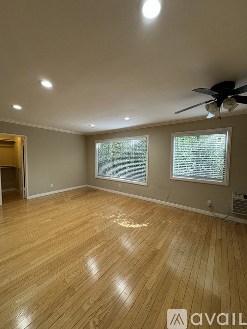 A room with wooden flooring and a ceiling fan.