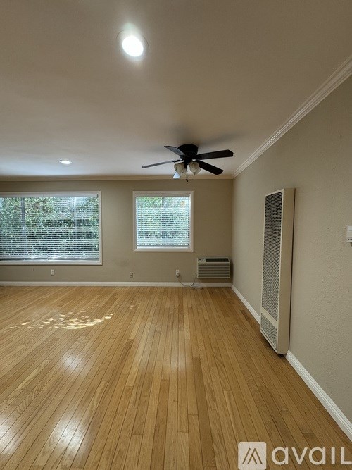A room with wooden flooring and a ceiling fan.