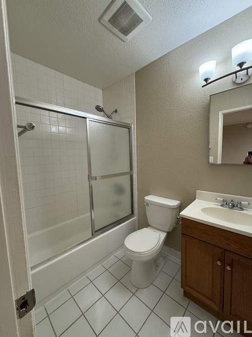 A bathroom with a toilet, sink, and shower.