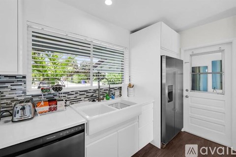 A kitchen with white cabinets and a black dishwasher.