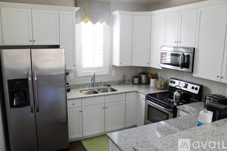 A kitchen with white cabinets and a granite countertop.
