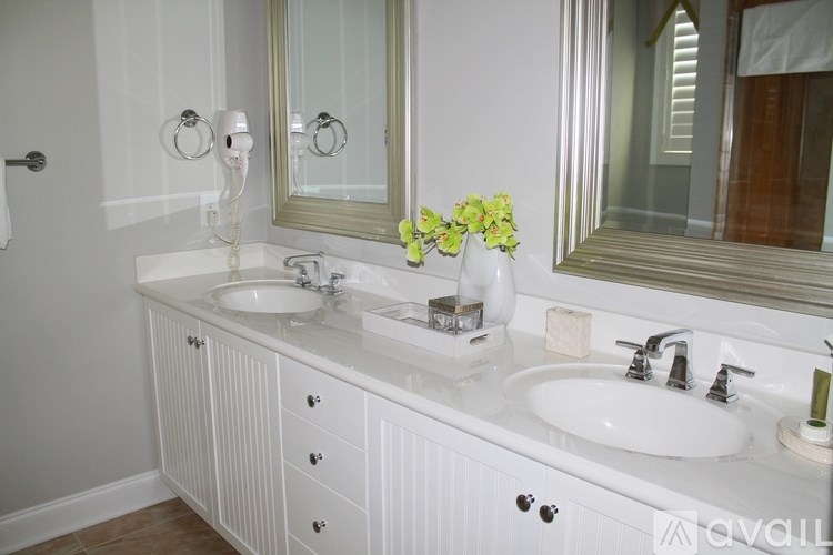 A bathroom with a white sink and a white cabinet.