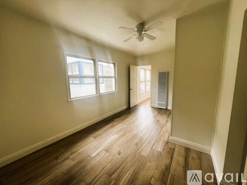A room with wooden flooring and a ceiling fan.