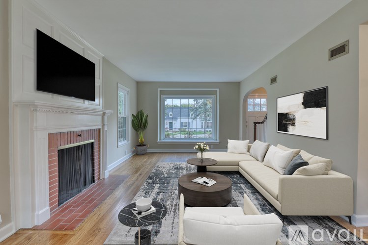 A house with a grey roof and white trim is surrounded by greenery.