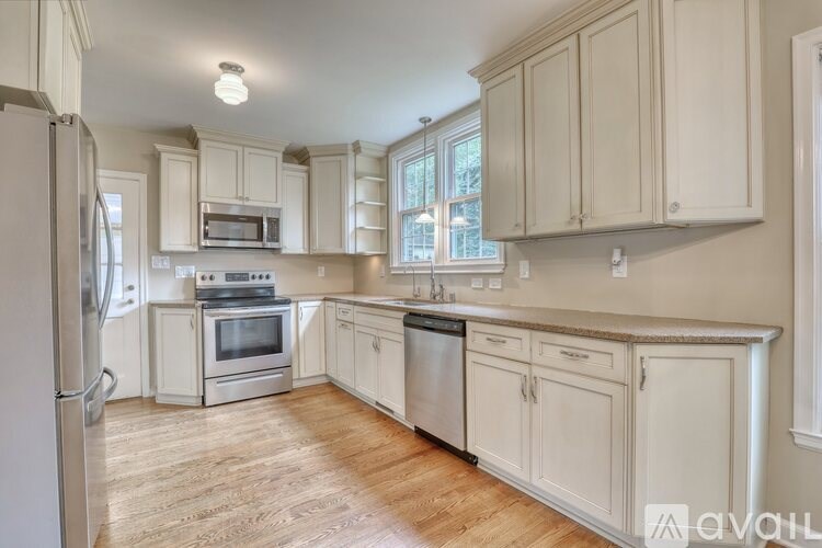A kitchen with white cabinets and a window.
