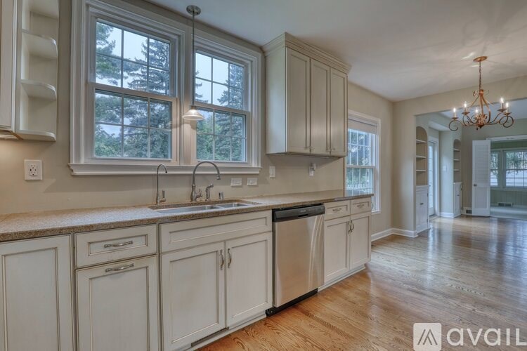 A modern kitchen with a black dishwasher and white cabinets.
