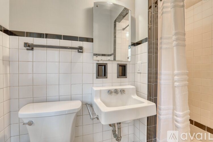 A white bathroom sink with a white toilet and a mirror above it.