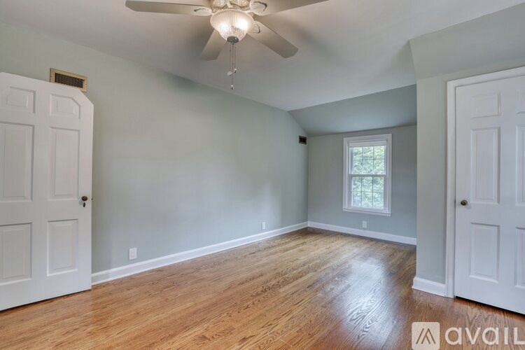 A room with a ceiling fan and wooden flooring.