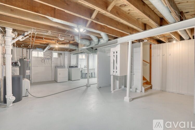 A spacious, empty room with a high ceiling and exposed ductwork.