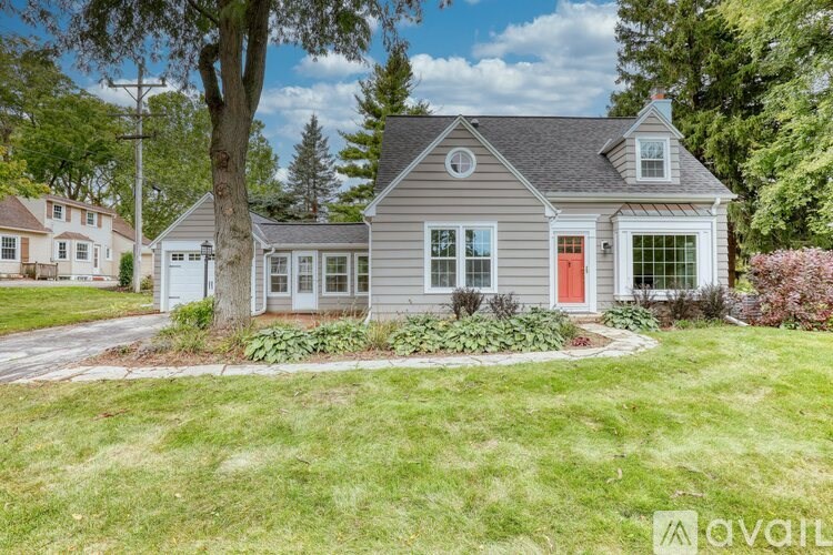 A house with a red door and a tree in front.