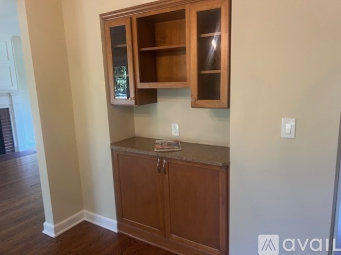 A wooden cabinet with glass doors is mounted on a wall.