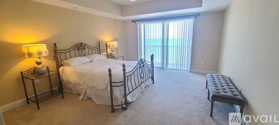 A bedroom with a bed, nightstands, and a window with blinds.