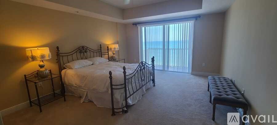 A bedroom with a large bed and a bench.