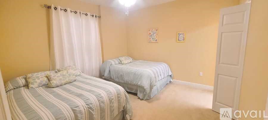 Two twin beds in a room with yellow walls.