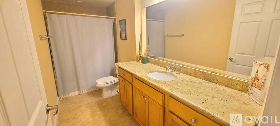 A bathroom with a toilet, sink, and shower.