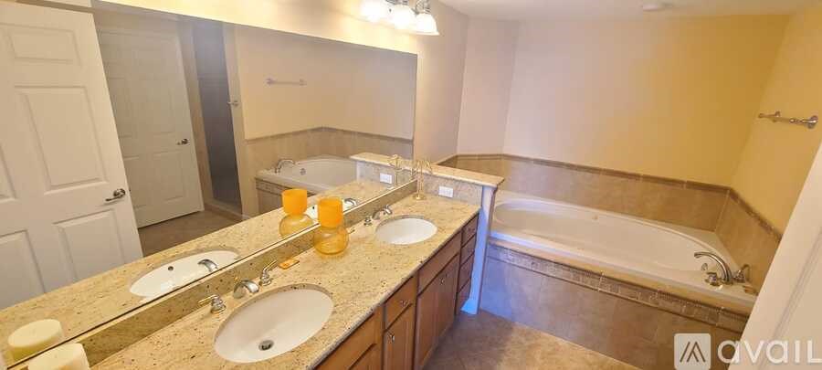 A bathroom with a tub, sink, and mirror.