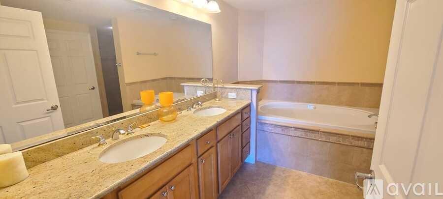 A bathroom with a tub, sink, and mirror.