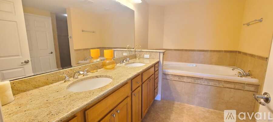 A bathroom with a tub, sink, and mirror.