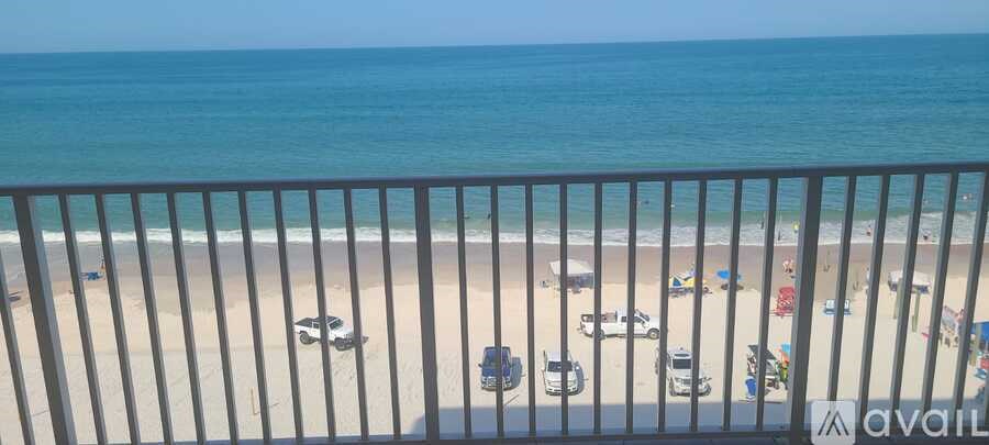 A beach scene with a blue ocean and a sandy shore.