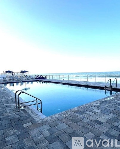 A pool with a metal railing and steps leading into the water.