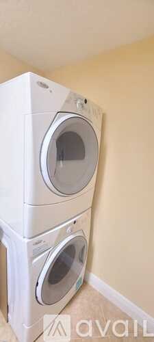 Two white washing machines stacked on top of each other.