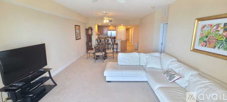 A living room with a white couch and a television.