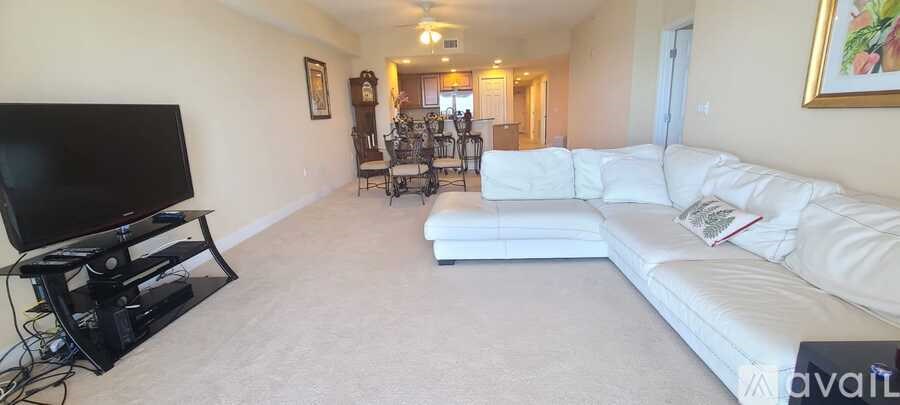 A living room with a white couch and a television.