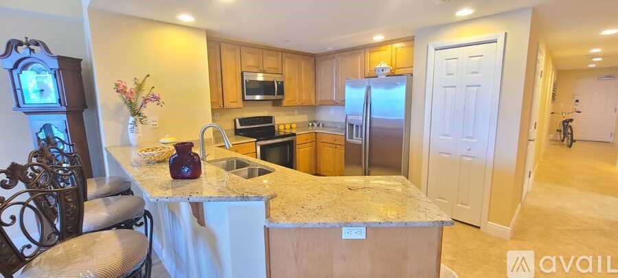 A kitchen with granite countertops and a refrigerator.