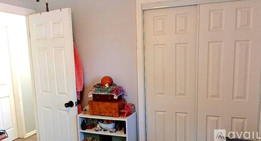 A white door with a decorated box on a shelf.