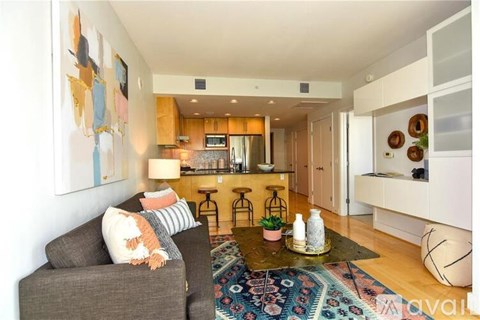 A living room with a grey couch and a coffee table in the middle.