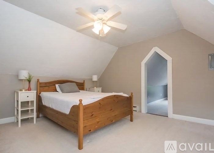A bedroom with a bed, nightstand, and a ceiling fan.