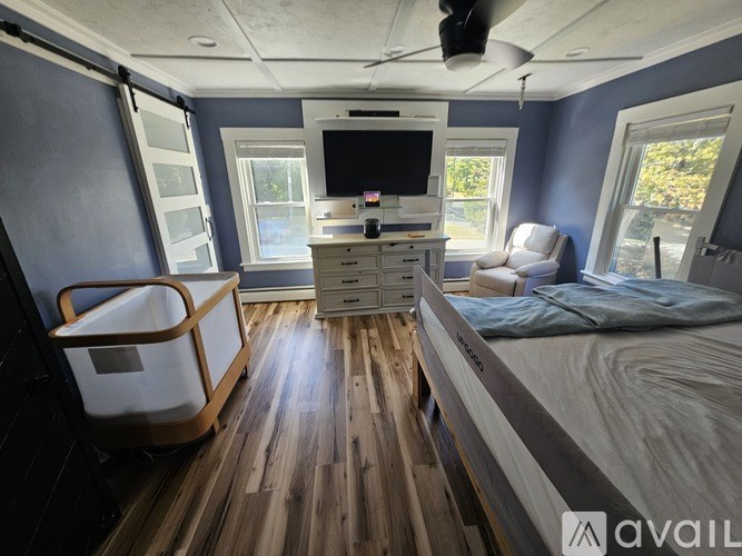 A bedroom with a bed, a television, and a desk.