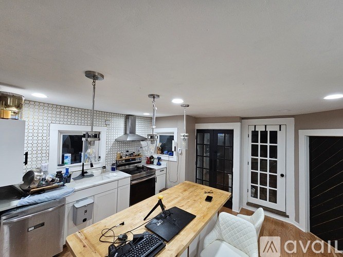 A kitchen with a wooden table and a laptop on it.