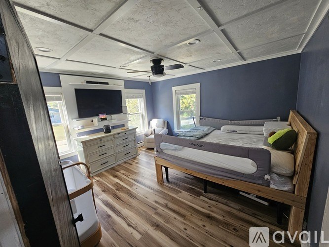 A bedroom with a bed, dresser, and television.
