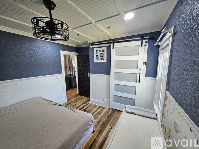 A bedroom with a bed, a wardrobe, and a ceiling fan.
