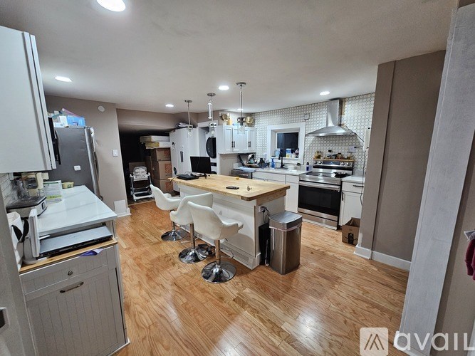 A kitchen with a wooden floor and white cabinets.