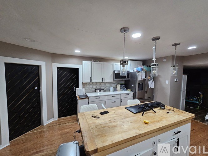 A kitchen with a wooden countertop and white cabinets.