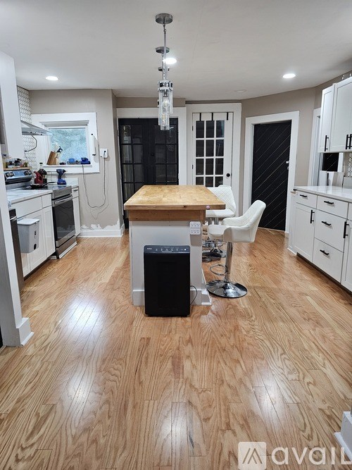 A kitchen with a wooden floor and white cabinets.