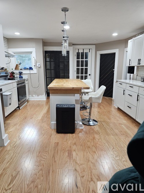 A kitchen with a wooden floor and white cabinets.