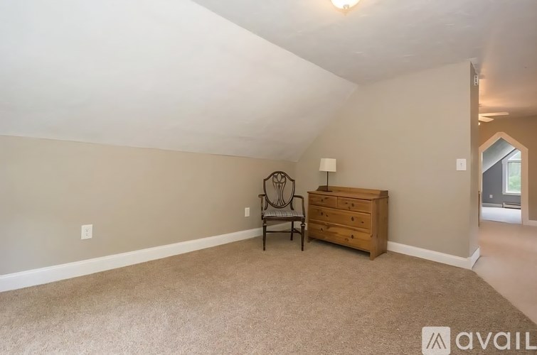 A room with a chair and a dresser in it.