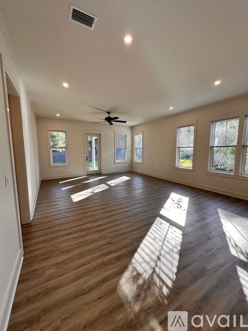 A bathroom with a sink, mirror, and wooden floors.