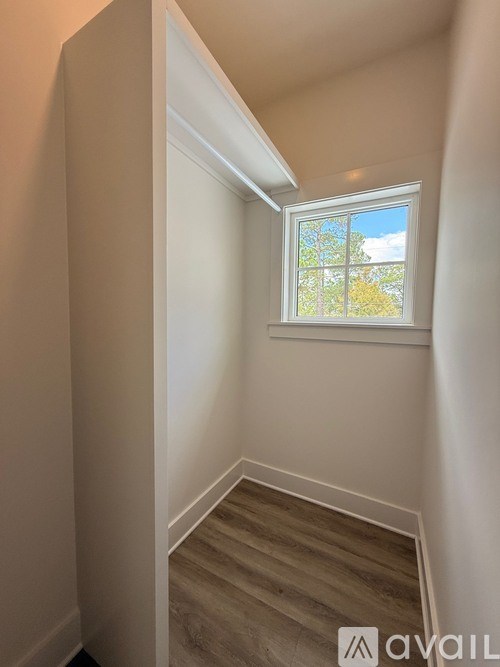 A room with a window and a wooden floor.