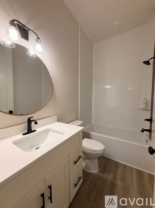 A bathroom with a sink, toilet, and mirror.
